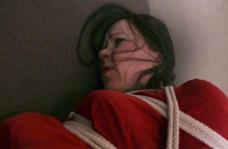 Caucasian woman exposes her stocking tops while tied up on a bed 47498429