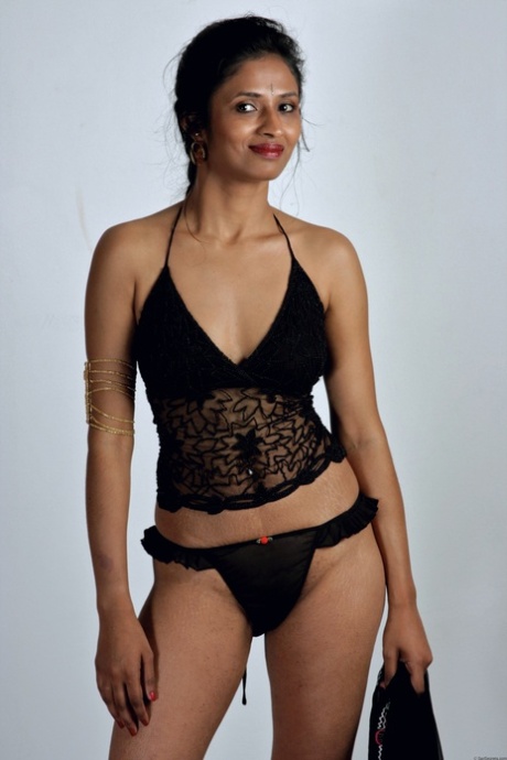 Slender Indian woman removes her sari to model in black lingerie 87149558