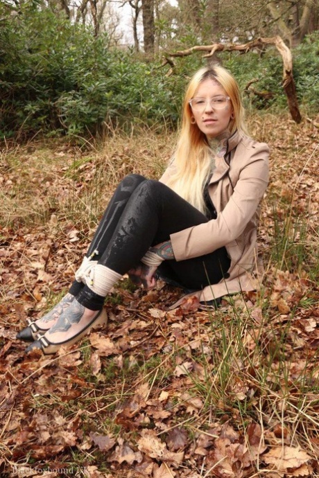 Clothed female is bound at her wrists and ankles while gagged in the woods 80140551