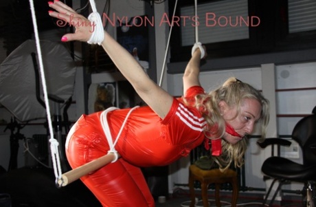 Natural blonde is restrained in a precarious position in shiny red pants 95826279