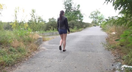 Leggy girl Amanda Hill pulls down shorts and panties for a pee on a paved path 85830658