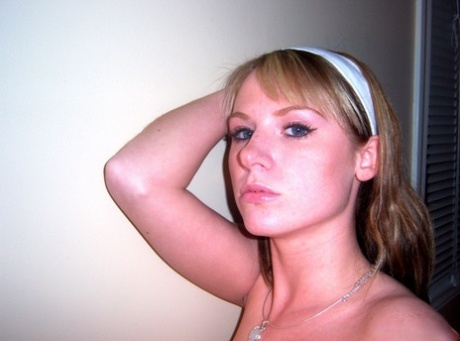 Blonde teen takes selfies while going topless in front of a mirror 40069897