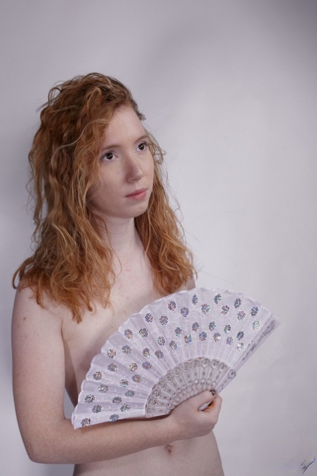 Natural redhead Nicki Blue fans herself while modeling for a nude solo shoot 67953035