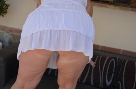 Older blonde BBW Melody strips to her underwear and heels on outdoor sofa 12516747
