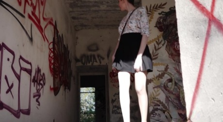 Solo girl with short hair squats for a piss inside a graffitied building 98722119