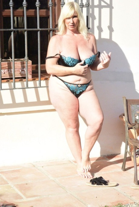 Older blonde Melody cradles her boobs after baring her overweight body 13874778