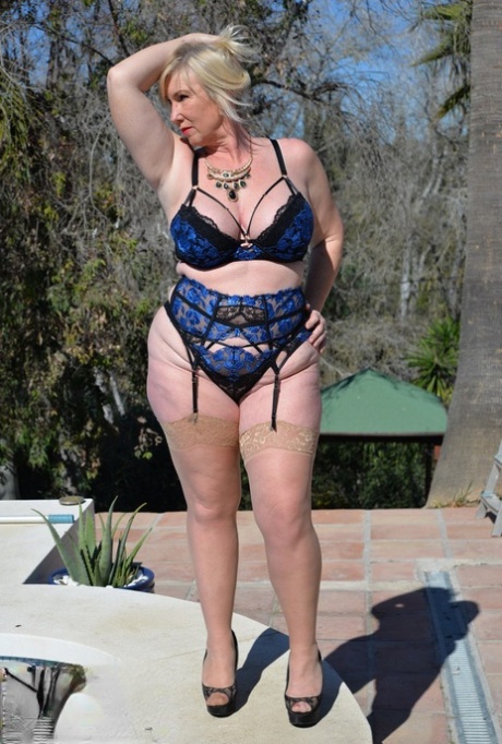 Overweight mature blonde Melody exposes her big natural tits near a pool 62306779