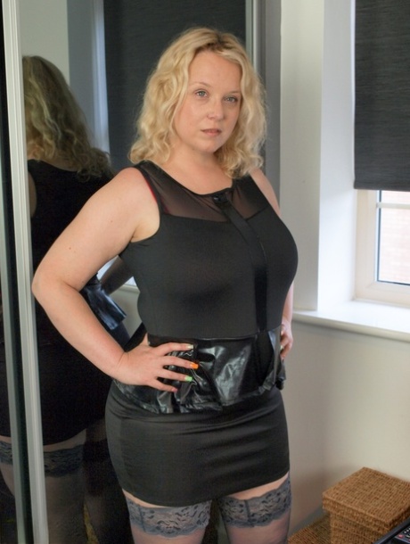 Blonde plumper Sindy Bust strips to her stockings on top of her bed 61407927