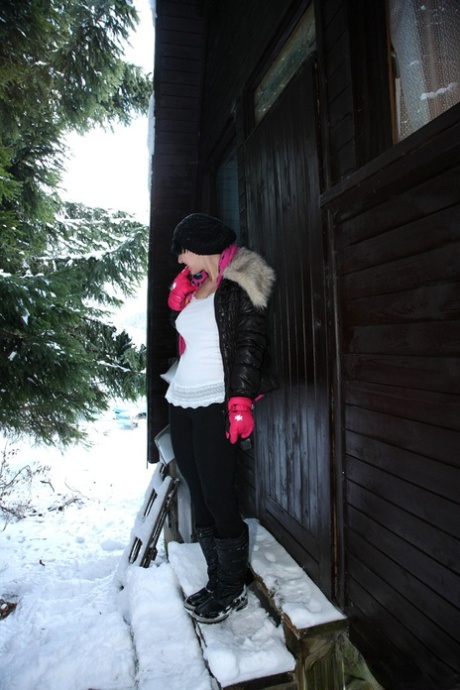 Barely legal brunette rubs her pussy on a snowy day behind a cabin in woods 40526873