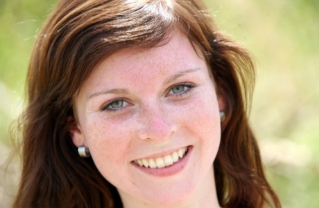 Redhead with freckles toys her shaved teen pussy in the grass beside dirt road 49169784