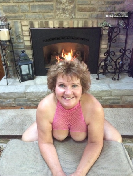 Mature woman Busty Bliss shows her natural tits in front of a fireplace 26381089