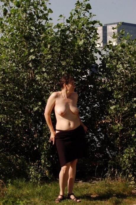 Mature lady Hotmilf takes off her dress to go topless in a public area 97208905
